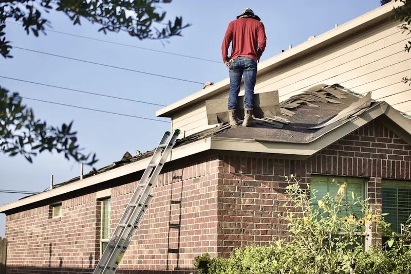 Professional roofer working on a residential roof in St. James